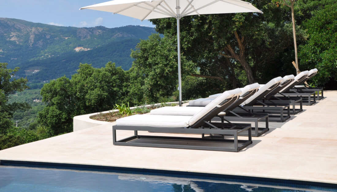 Terrassen Gestaltungsidee - Moderne Terrasse mit Sonnenschirm & Liegen mit Blick ins Tal 