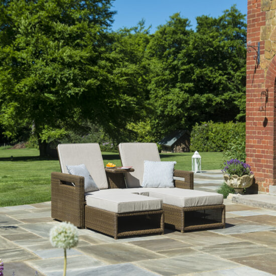 Terrassen Idee - Beispiel mit modern gefertigten Liegen aus Rattan mit Polsterung & eingearbeiteten Tisch auf der Terrasse - weiße Gartenlaterne & Wandleuchte