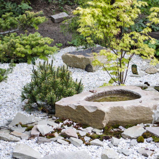 Schöner Steingarten mit asiatscher Dekoration und Bepflanzung