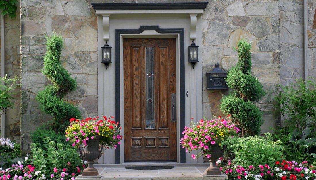 Schöner Hauseingang mit außergewöhnlicher Tür und Blumen