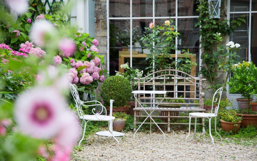 Gartenidee – Schöner Blumengarten vor großem Fenster mit Sitzgelegenheiten – Weiße Edelstahl Sitzgruppe & Buchsbaum