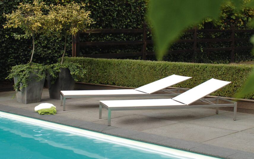 Gartenidee – Gestaltungsbeispiel mit Pool – kleiner Terrasse mit Liegen & niedriger  sowie hochgewachsener Hecke als Sichtschutz