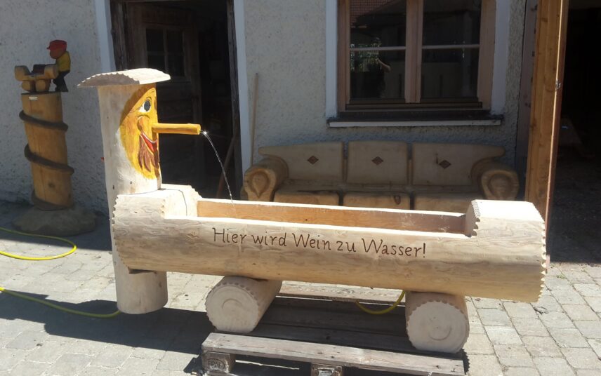 Innenhof Idee – Holztränke mit ungewöhnlicher Schnitzerei als Dekoration & geschnitzte Holzbank – Brunnen aus Baumstamm