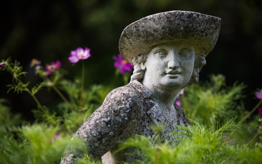 Gartengestaltung mit Skulptur zwischen Pflanzen – Französische Skulptur eines jungen Mannes aus Stein