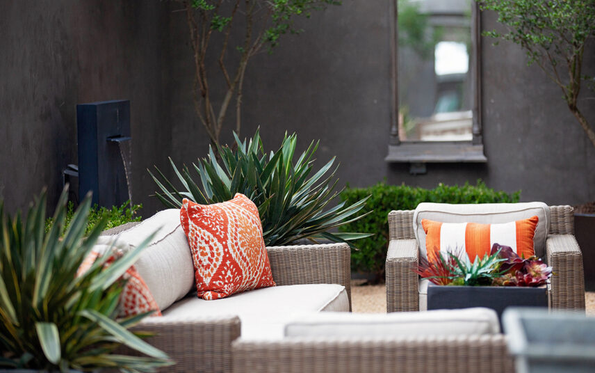 Terrasse im Innenhof Idee – Moderne Terrasse mit bequemen Rattanmöbeln  Wandbrunnen und eleganter Bepflanzung