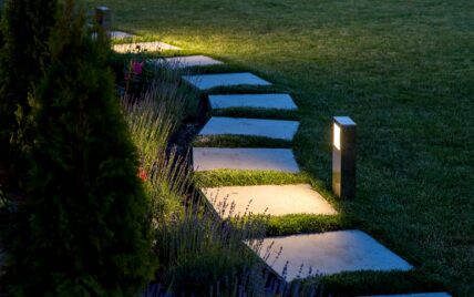Gartenweg Idee – Beleuchteter Gartenweg aus einzelnen Steinplatten in modernem Vorgarten...