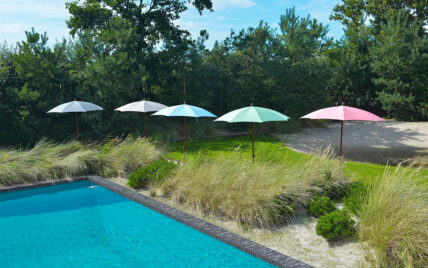Idee für einen Garten mit Pool – Farbenfrohe Sonnenschirme in moderner Optik an großem...
