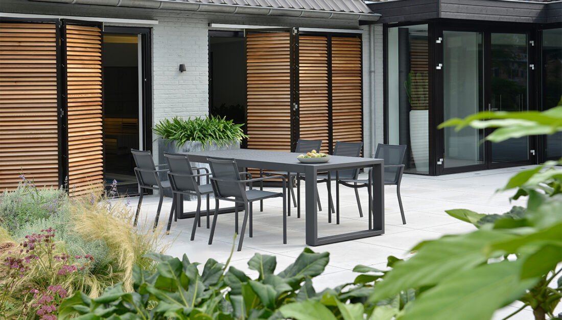 Gartenidee für die Terrasse - Klare Linie mit einer modernen Sitzgruppe auf großer Terrasse im Innenhof - Terrassenpflanzen in Pflanzkübeln
