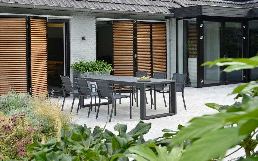 Gartenidee für die Terrasse – Klare Linie mit einer modernen Sitzgruppe auf großer Terrasse im Innenhof – Terrassenpflanzen in Pflanzkübeln
