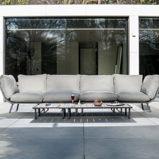 Moderne Terrassenidee - Beispiel mit großem Loungesofa & Loungetisch vor der Glasfassade des Hauses