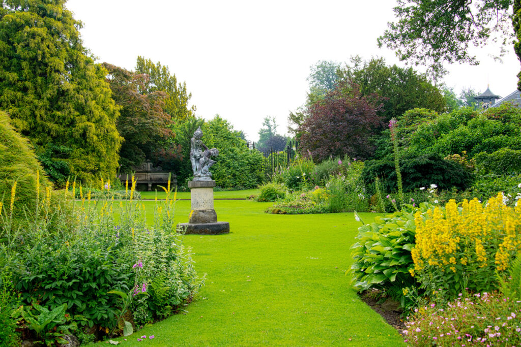 Gestaltung eines englischen Gartens mit Steinskulptur