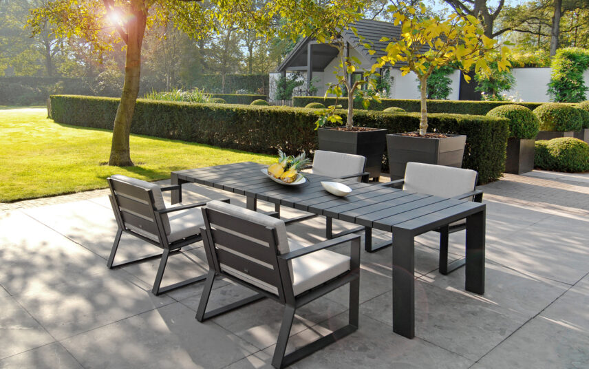 Moderne Gartengestaltung mit Terrasse und schwarzer Sitzgruppe – Beispiel mit Buchsbaumhecken & gemähten Rasen mit Baum