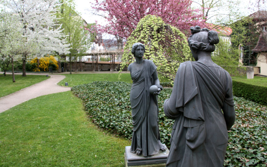 Idee für einen kleinen Park – Frommannscher Garten Jena – Beispiel mit zwei dunklen Skulpturen am Parkweg – Sitzbereiche mit Holzpergolen & Bänken