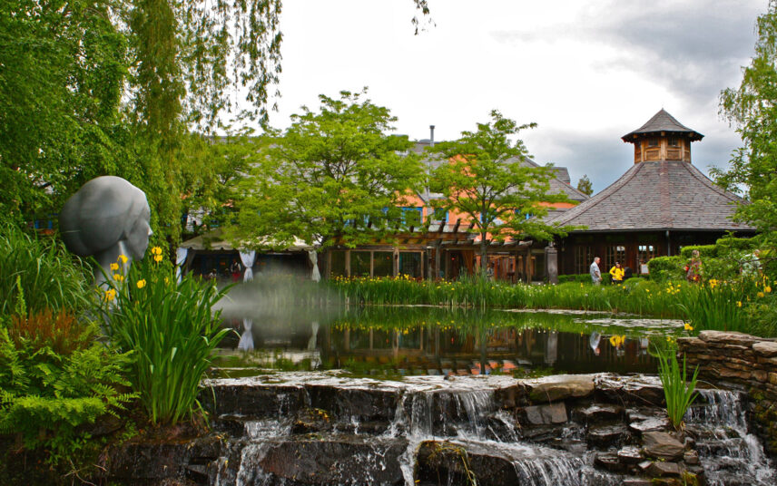 Parkgestaltung mit Teich & Wasserfall – Beispiel mit vielen Pflanzen & Skulptur am Teichrand