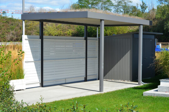 Gartenidee – Kleiner moderner Carport aus Alu mit Sichtschutzwand & Dachbegrünung – Kleines Gartenhaus aus Metall als Geräteschuppen & Gartensträucher