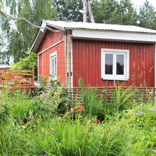 Wilder natürlicher Garten mit roten Gartenhaus als Gartenidee - Beispiel mit Stauden & Blumen im Garten - Selbstgebauter Holzzaun & Metallzaun