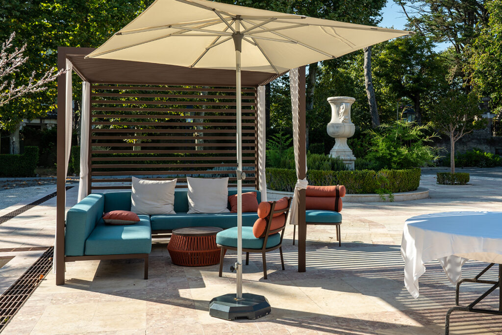 Gartengestaltung mit gepflasterte Natursteinfläche & modernem Sitzbereich