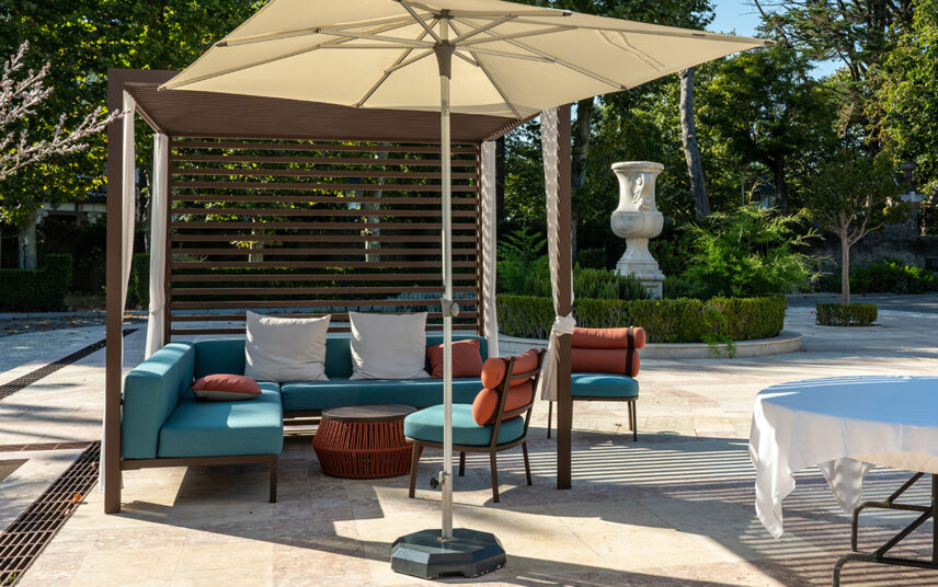 Idee für die moderne Terrassengestaltung – Beispiel mit moderner Pergola aus Metall & Terrassen Sonnenschutz – Loungesofa  Beistelltisch & Stühle – Pflanzkübel