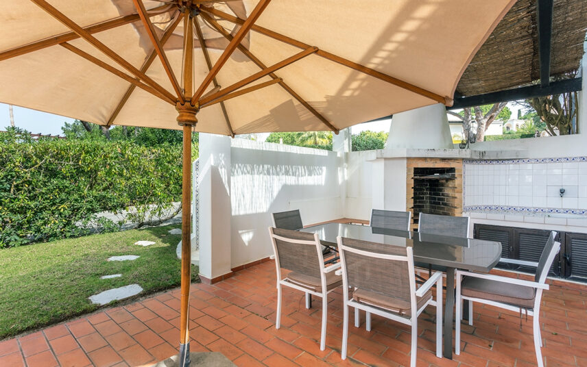 Moderne Terrassengestaltung mit Sonnenschutz und Terrassenüberdachung – Beispiel mit Sitzgruppe & Outdoor Küche mit Kamin- Rote Terrassensteine
