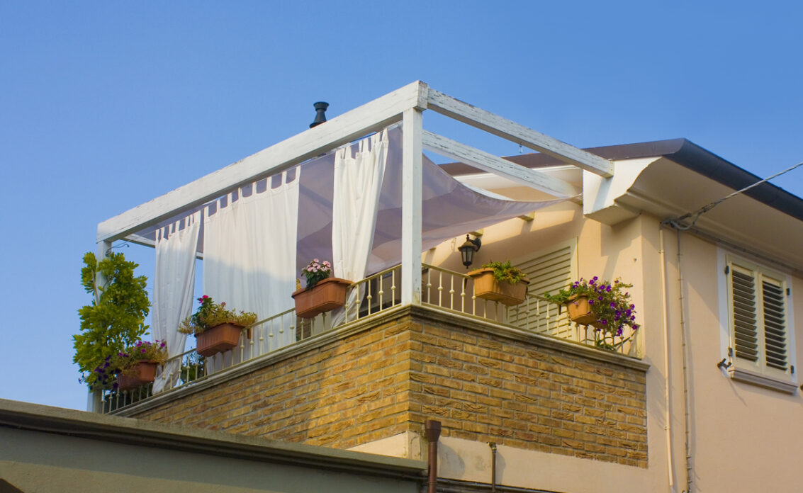 Balkongestaltung mit Sonnenschutz – Vorhängen an der Pergola – Idee mit Blumenkästen...