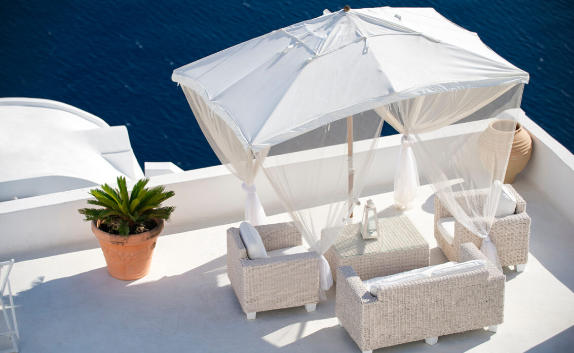 Idee für einen großen Balkon mit weißer Rattansitzgruppe  Laterne & Sonnenschirm mit Vo...