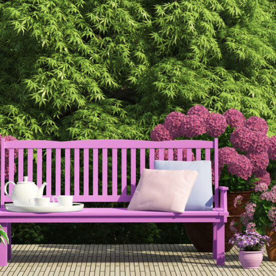Beispiel für den Garten - Idee für eine Sitzecke mit lila Bank  & Kissen umgeben von Gartenpflanzen & Hortensien - Pflanzgefäße mit Blumen
