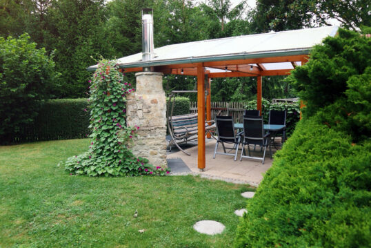 Idee für eine Terrasse mit Überdachung und Sitzgruppe – Beispiel mit bepflanz...