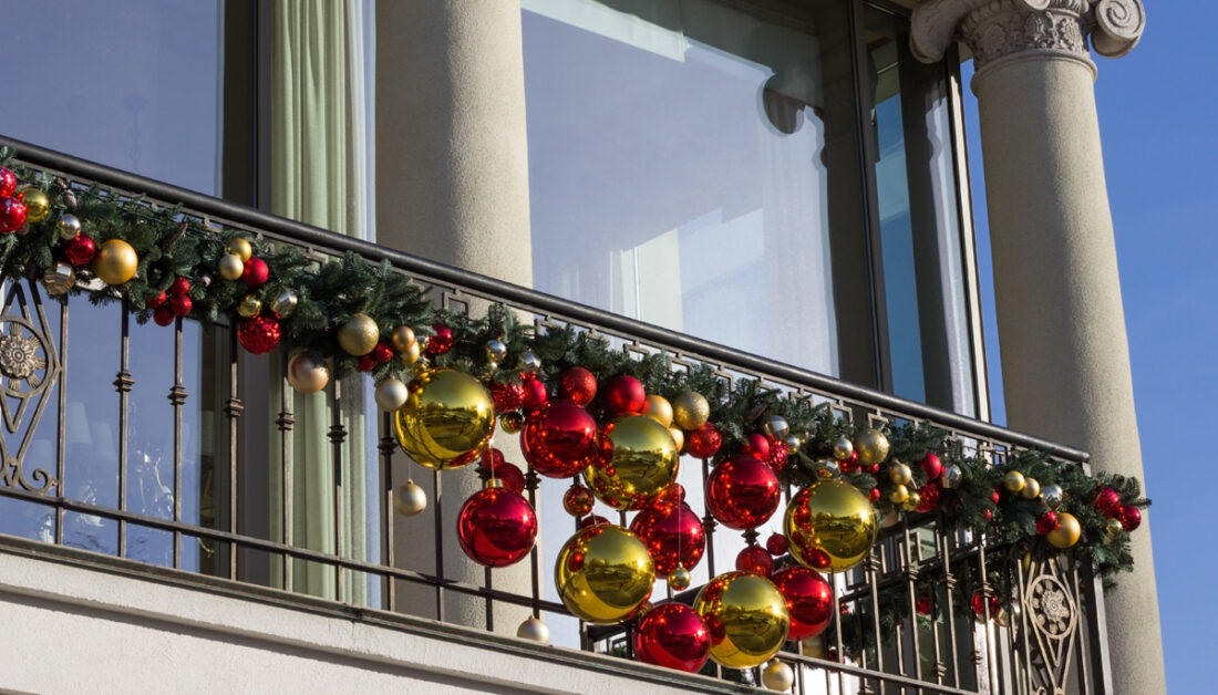 Stilvolle Idee für die Balkongestaltung mit Weihnachtsdeko - Weihnachtsgirlande mit großen & kleinen Weihnachtskugeln am Balkongeländer