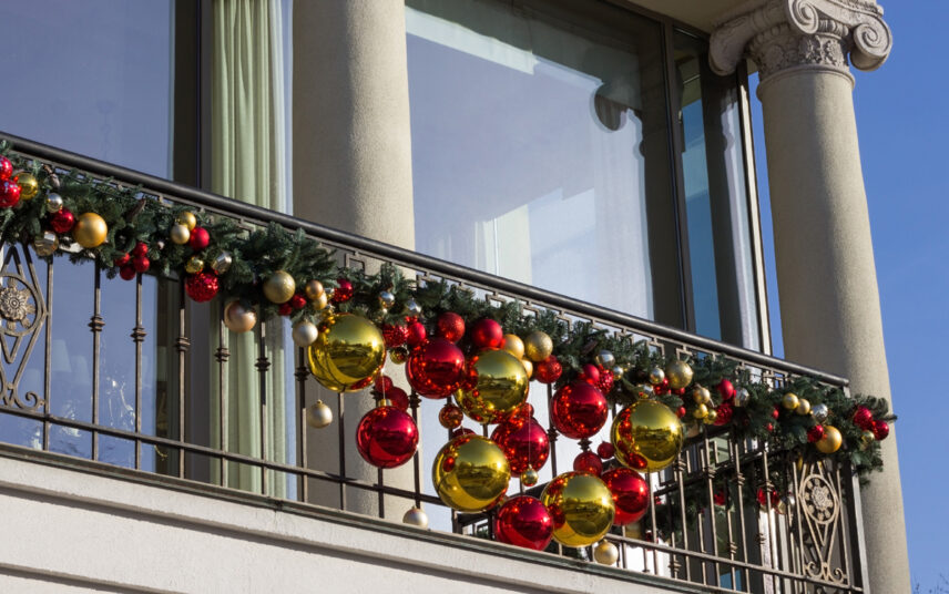 Stilvolle Idee für die Balkongestaltung mit Weihnachtsdeko – Weihnachtsgirlande mit großen & kleinen Weihnachtskugeln am Balkongeländer