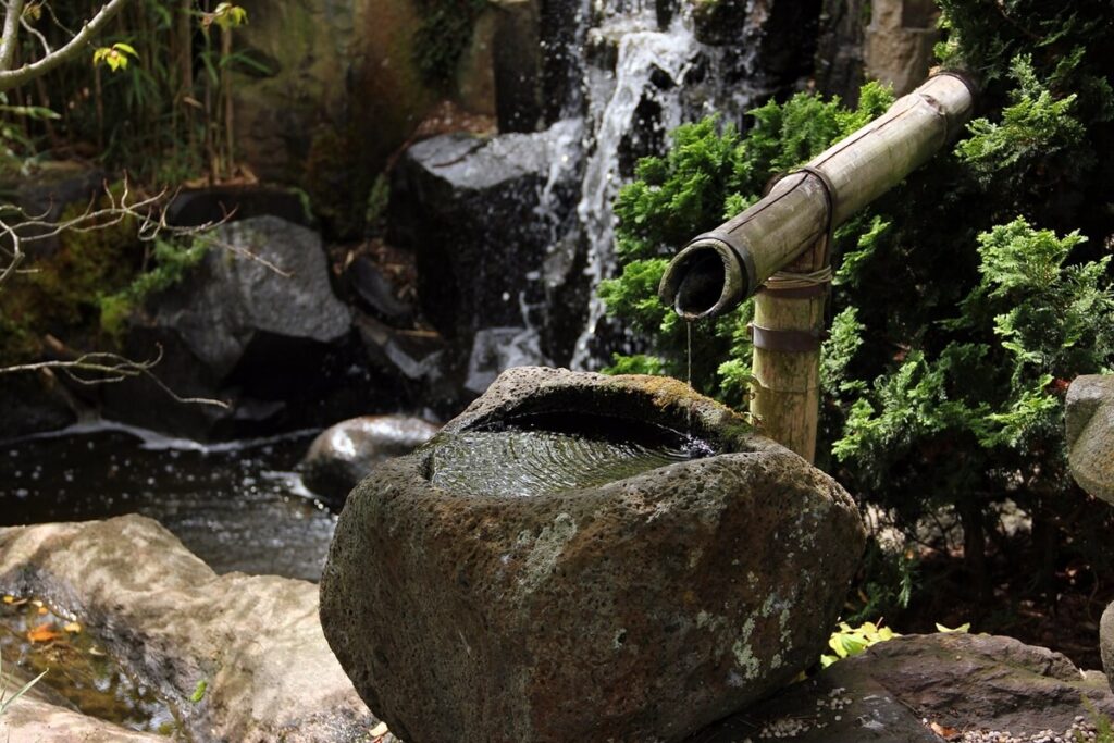 Ein romantisch-rustikal erscheinendes Steinwasserbecken fügt sich optimal in eine natürliche Gartengestaltung ein.