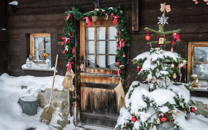 Beispiel für ein Landhaus aus Holz mit Weihnachtsdekoration – Hauseingang Idee mit Weihnachtsgirlande & geschmückten Weihnachtsbaum