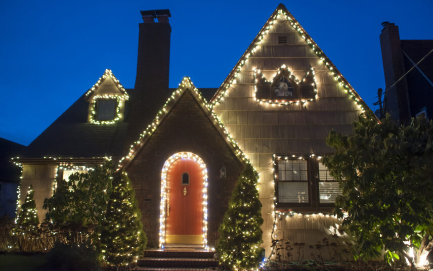 Ländliches Haus dekoriert mit Weihnachtsdekoration – Beispiel mit LED-Lichterketten am ganzen Haus – Bäume vor dem Hauseingang