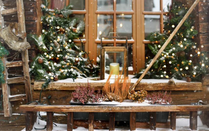 Außenbereich Idee mit Winterdekoration auf und vor der Fensterbank – Beispiel mit Laterne  Tannenzweigen & Lichterketten – bepflanzter Blumenkasten