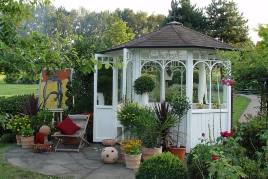 Beispiel für die Gartengestaltung – Weißer Pavillon mit vielen Fenstern im lä...