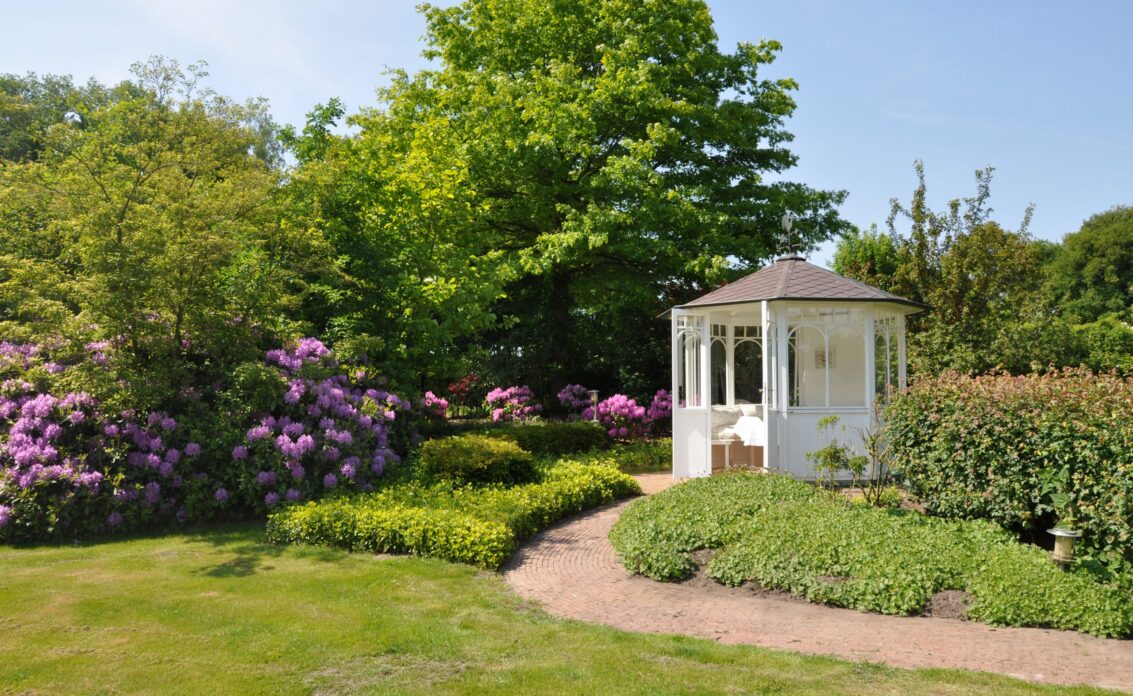 Romantische Gartenidee mit weißen Pavillon – Angelegter Gartenweg mit Pflanzen rechts &...