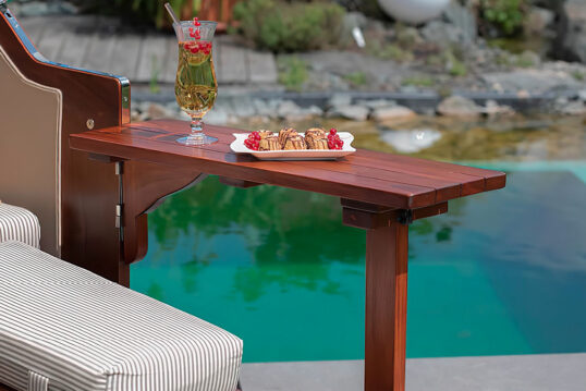 Gartenidee – Strandkorb mit Tisch zum Servieren von Essen & Cocktails – Natürlicher Pool im Hintergrund