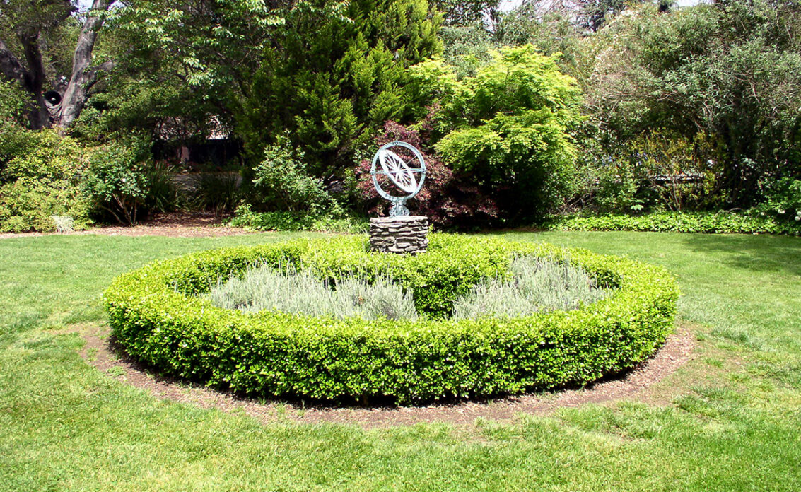 Sonnenuhr Idee für den Garten – Rustikale Uhr umrundet von einem Beet