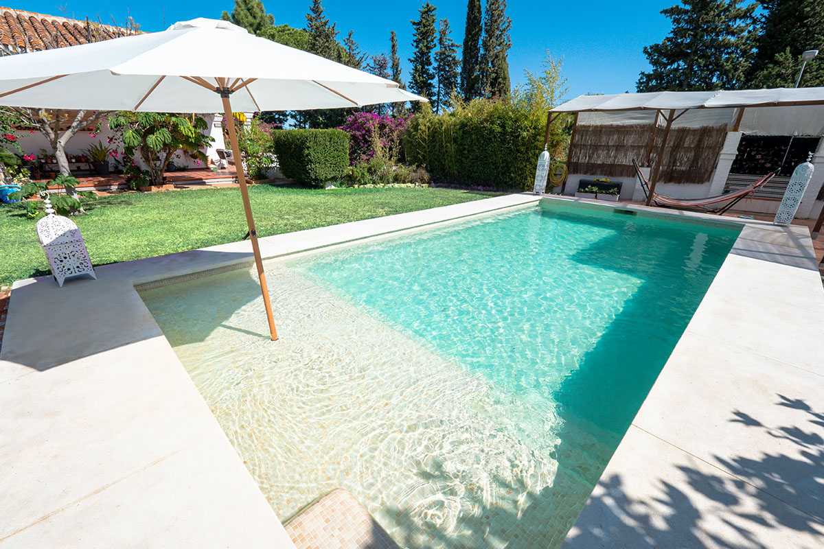 Pool im Garten mit fast stufenlosen Eintritt und kombiniert mit einem Sonnenschirm
