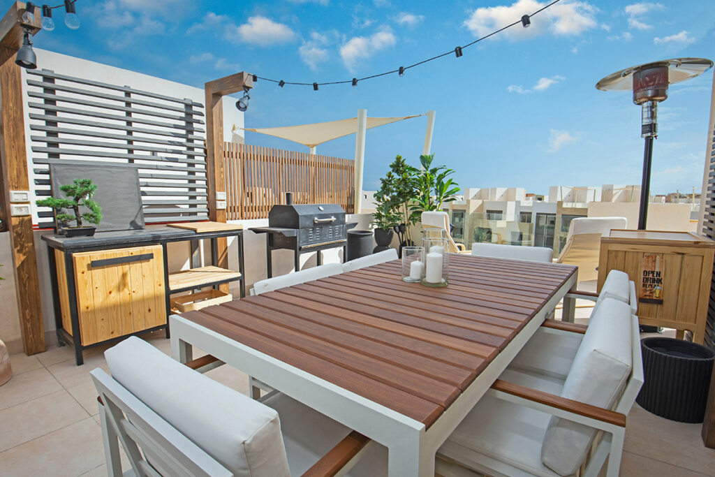 Dachterrassen Beispiel mit großen modernen Esstisch aus Holz und Metall, sowie den passenden Stühlen.