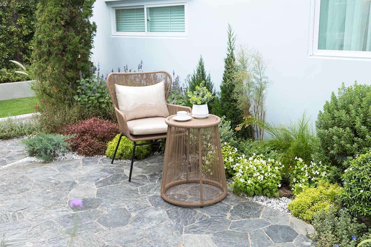 Beispiel für einen kleinen Sitzplatz auf der Terrasse mit modernen Korbstuhl und Korbtisch.