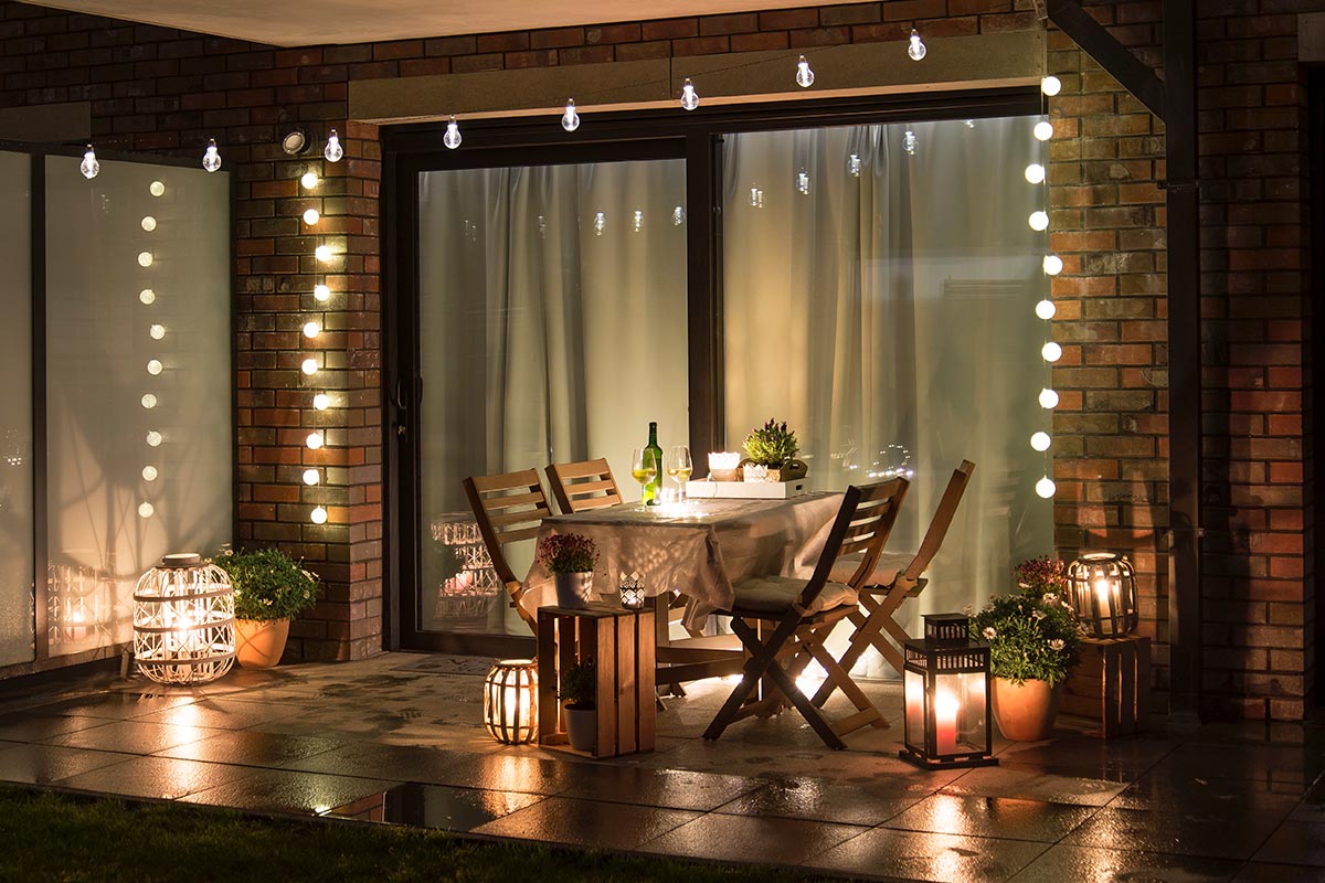 Beleuchtete Terrasse mit Sitzgruppe und Lichterketten
