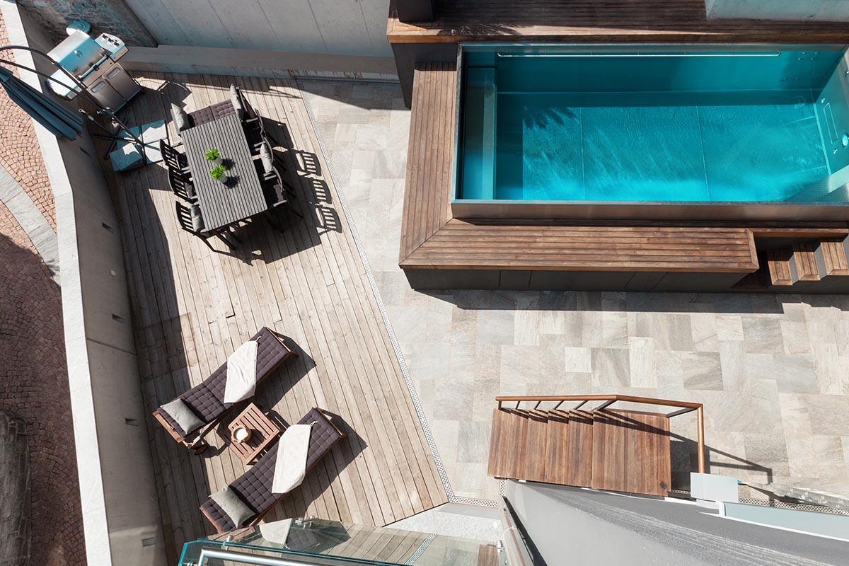 Modern angelegte Terrasse mit Pool, Liegen und Sitzgruppe.