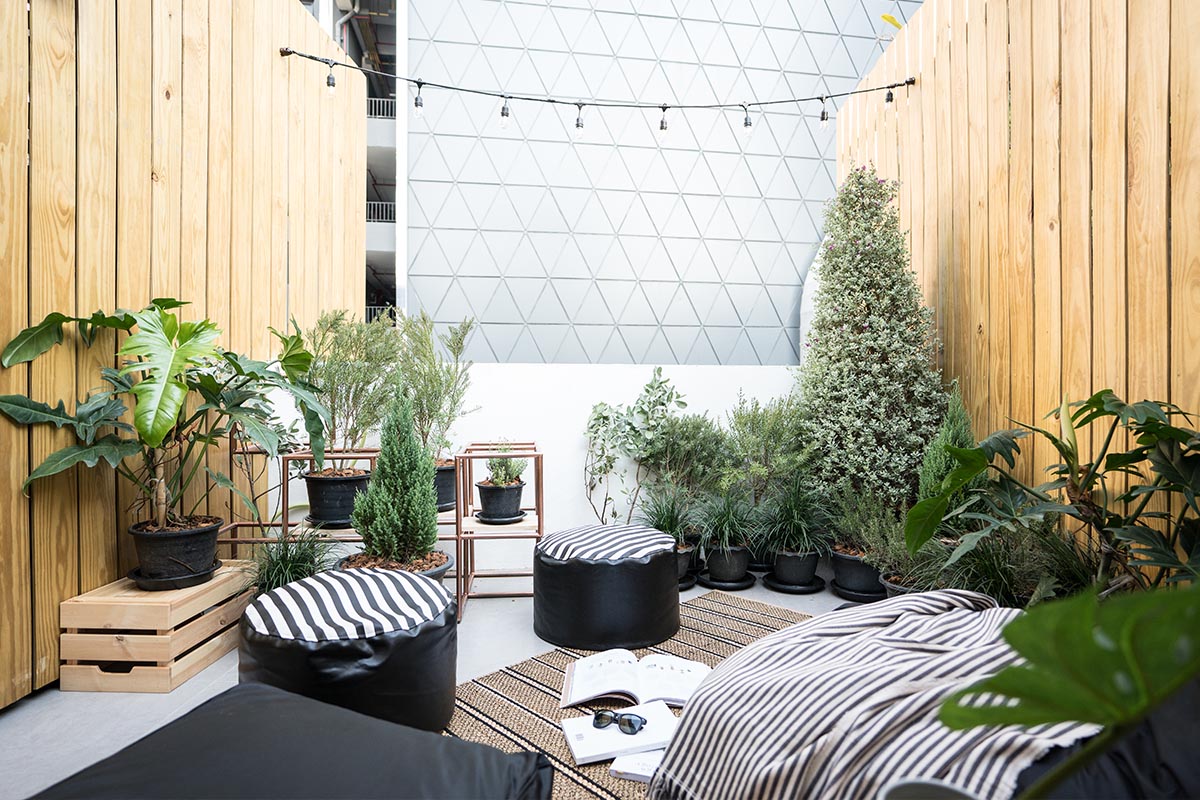 Terrasse skandinavisch eingerichtet mit verschiedenen Sitzgelegenheiten, Textilien und Pflanzen.