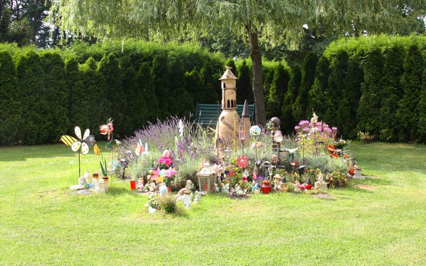 Kunterbunte Gemeinschaftsgrabstätte für Kinder mit einem Grabstein als Burg aus Keramik – Bunter Grabschmuck & Grablampen sowie Grabbepflanzung mit Lavendel