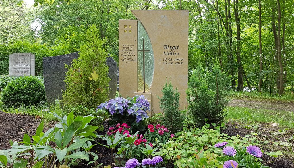 Moderner Einzelgrabstein aus Kalkstein mit Glaselement und Kreuz - pflegeleichte Grabbepflanzung mit Stauden und Sommerblumen