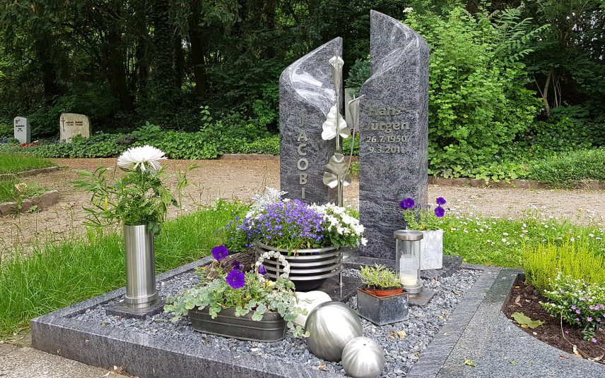 Grabidee – Zweiteiliges Urnengrabmal aus Granit mit Einfassung – moderne Grabgestaltung mit Kies & Grabschmuck aus gebürstetem Metall