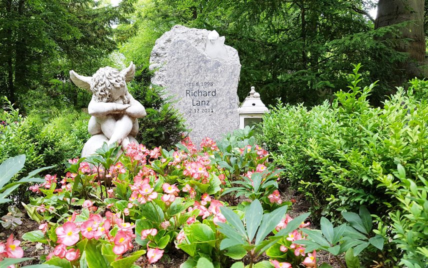 Schönes Kindergrab aus hellem Granit mit Bergkristall – moderne Grabgestaltung mit Grabschmuck & sommerlicher Bepflanzung
