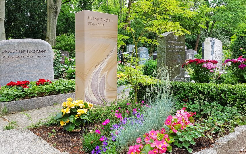 Moderner Grabstein aus Sandstein auf einem Urnengrab – sommerliche Bepflanzung mit bunten pflegeleichten Blumen & Gräsern