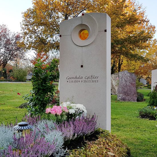 Modernes Einzelgrab aus hellem Kalkstein mit Glaseinsatz & Grabbepflanzung zu Allerheiligen mit Herbststauden & Grablampe