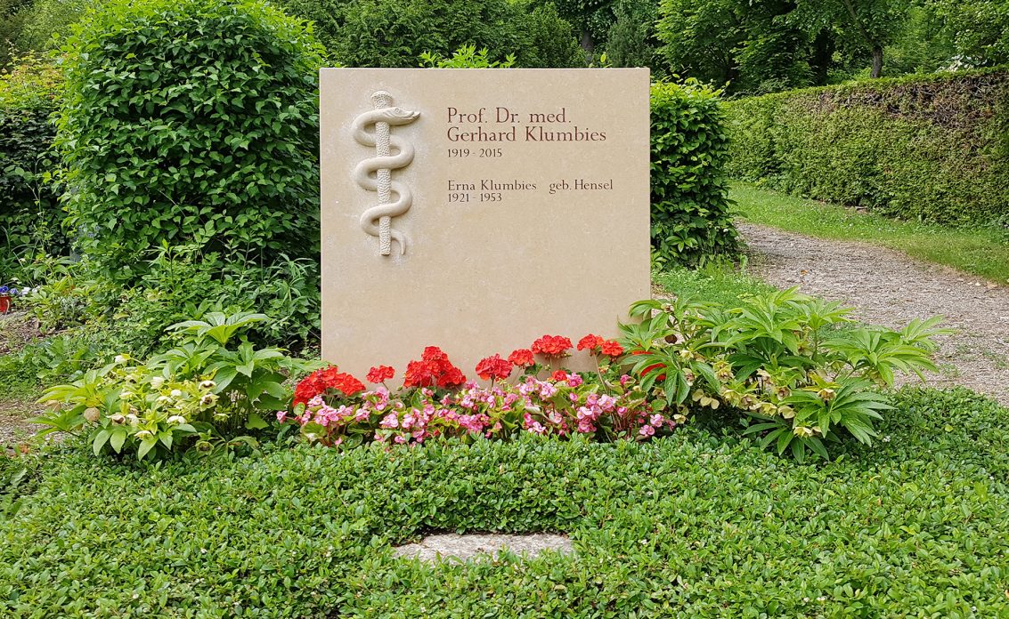 Großer Grabstein aus hellem Kalkstein für ein Familiengrab – moderne Grabbepflanzung m...